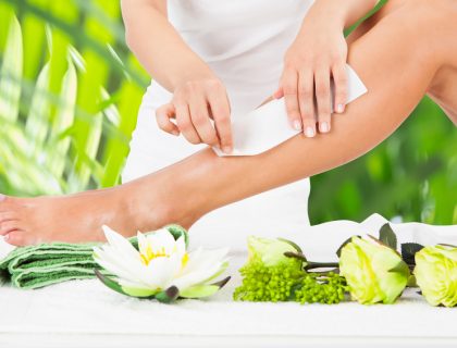 Beautician Waxing Woman's Leg In Spa